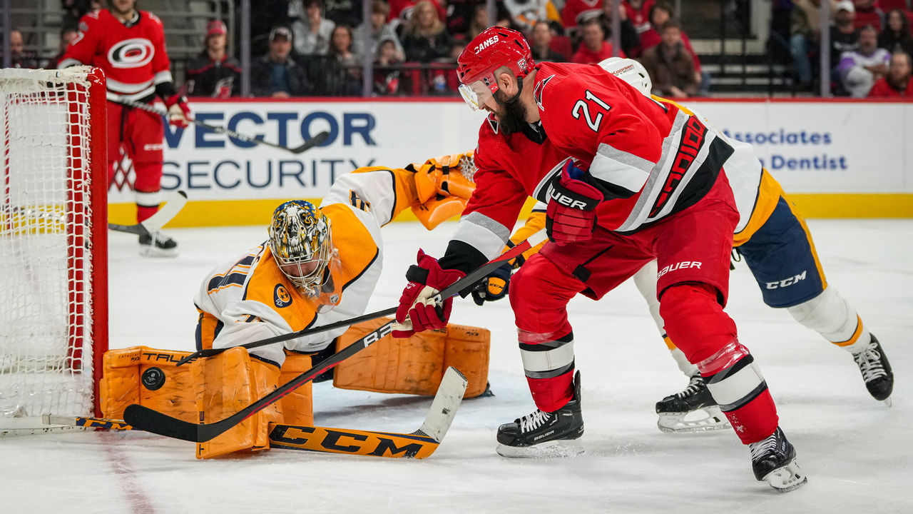 RALEIGH, NORTH CAROLINA - JANUARY 05: Juuse Saros #74 of the Nashville Predators defends the net against Derek Stepan #21 of the Carolina Hurricanes during the third period at PNC Arena on January 05, 2023 in Raleigh, North Carolina.