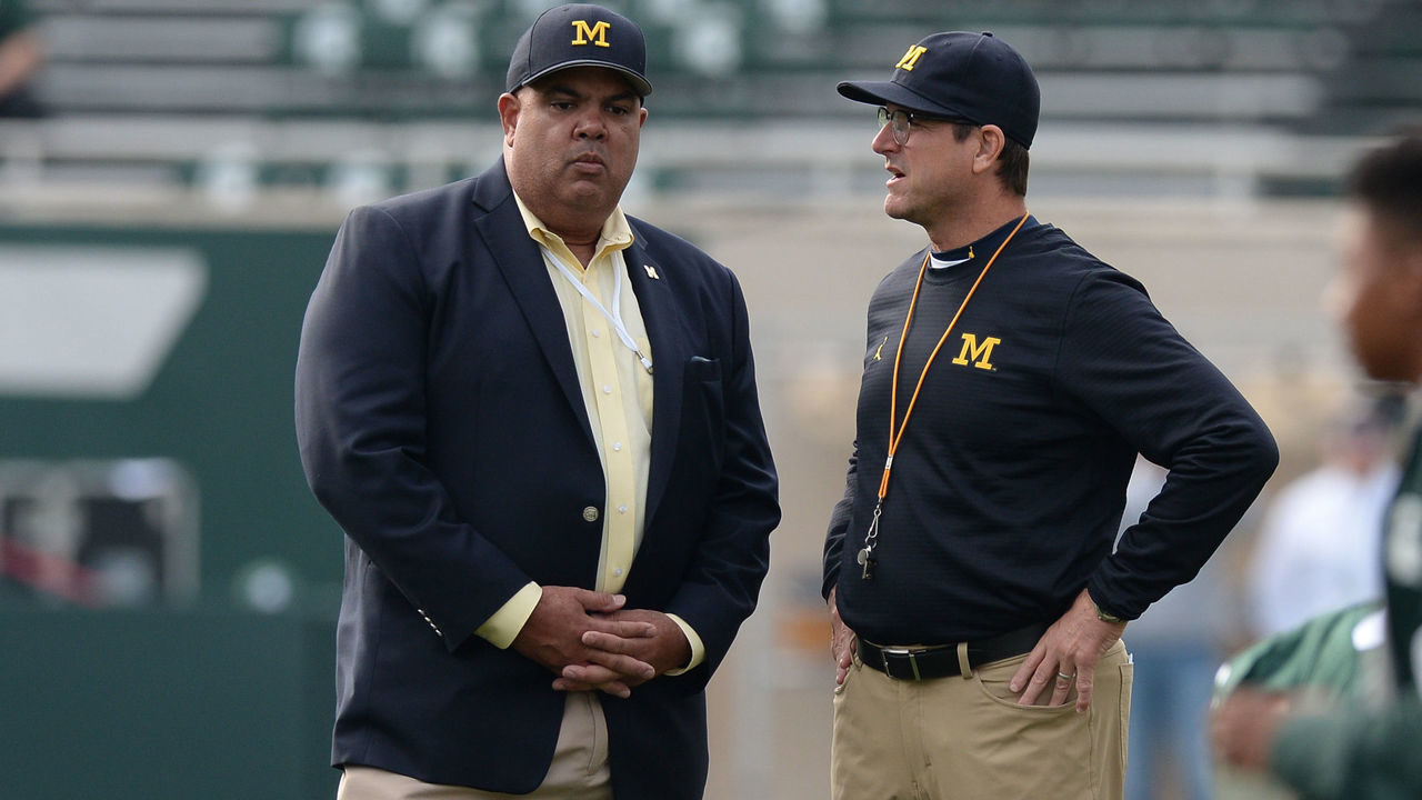 EAST LANSING, MI - OCTOBER 29: Wolverines head coach Jim Harbaugh and Director of Athletics Warde Manuel chat prior to a Big Ten Conference NCAA football game between Michigan State and Michigan on October 29, 2016, at Spartan Stadium in East Lansing, MI. Michigan defeated Michigan State 32-23.