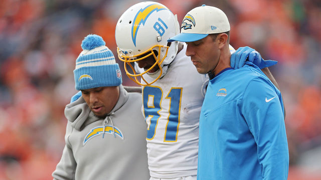 DENVER, COLORADO - JANUARY 08: Trainers assist Mike Williams #81 of the Los Angeles Chargers off the field during the first half against the Denver Broncos at Empower Field At Mile High on January 08, 2023 in Denver, Colorado.