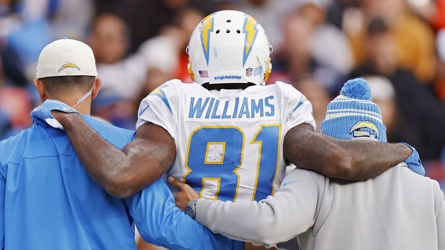 DENVER, COLORADO - JANUARY 08: Trainers assist Mike Williams #81 of the Los Angeles Chargers off the field during the first half against the Denver Broncos at Empower Field At Mile High on January 08, 2023 in Denver, Colorado.