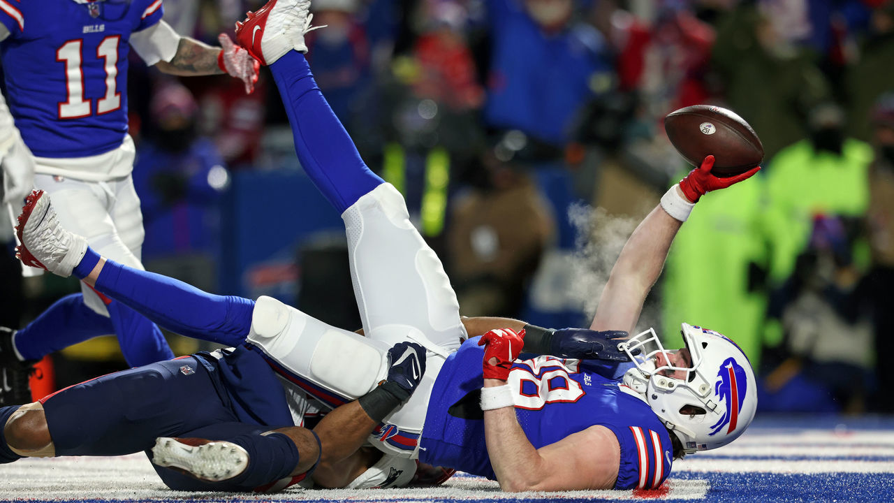 BUFFALO, NEW YORK - JANUARY 15: Dawson Knox #88 of the Buffalo Bills catches a touchdown pass against Adrian Phillips #21 of the New England Patriots during the first quarter in the AFC Wild Card playoff game at Highmark Stadium on January 15, 2022 in Buffalo, New York.