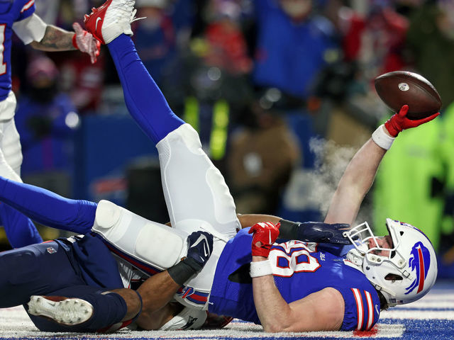 BUFFALO, NEW YORK - JANUARY 15: Dawson Knox #88 of the Buffalo Bills catches a touchdown pass against Adrian Phillips #21 of the New England Patriots during the first quarter in the AFC Wild Card playoff game at Highmark Stadium on January 15, 2022 in Buffalo, New York.