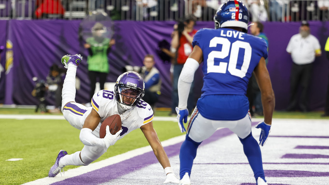 MINNEAPOLIS, MN - DECEMBER 24: Justin Jefferson #18 of the Minnesota Vikings dives for a touchdown while Julian Love #20 of the New York Giants defends in the fourth quarter of the game at U.S. Bank Stadium on December 24, 2022 in Minneapolis, Minnesota. The Vikings defeated the Giants 27-24.