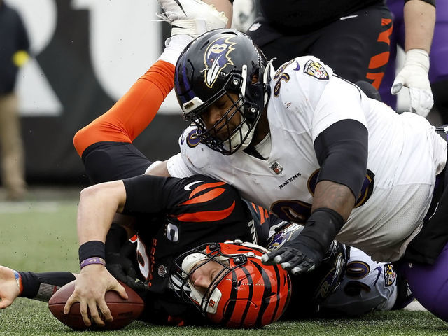 CINCINNATI, OH - JANUARY 08: Joe Burrow #9 of the Cincinnati Bengals is tackled by Travis Jones #98 of the Baltimore Ravens during the game at Paycor Stadium on January 8, 2023 in Cincinnati, Ohio.
