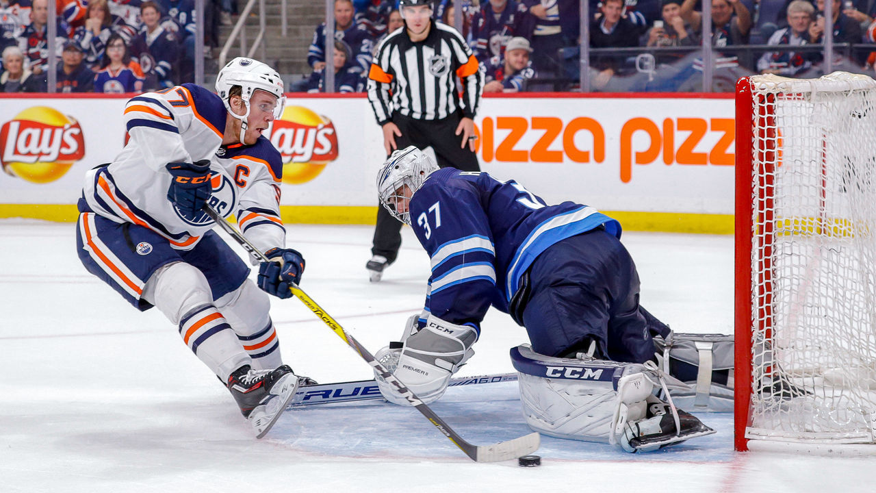 WINNIPEG, MB - OCTOBER 20: Goaltender Connor Hellebuyck #37 of the Winnipeg Jets slides across the crease to stop a shot by Connor McDavid #97 of the Edmonton Oilers during the shootout at the Bell MTS Place on October 20, 2019 in Winnipeg, Manitoba, Canada.