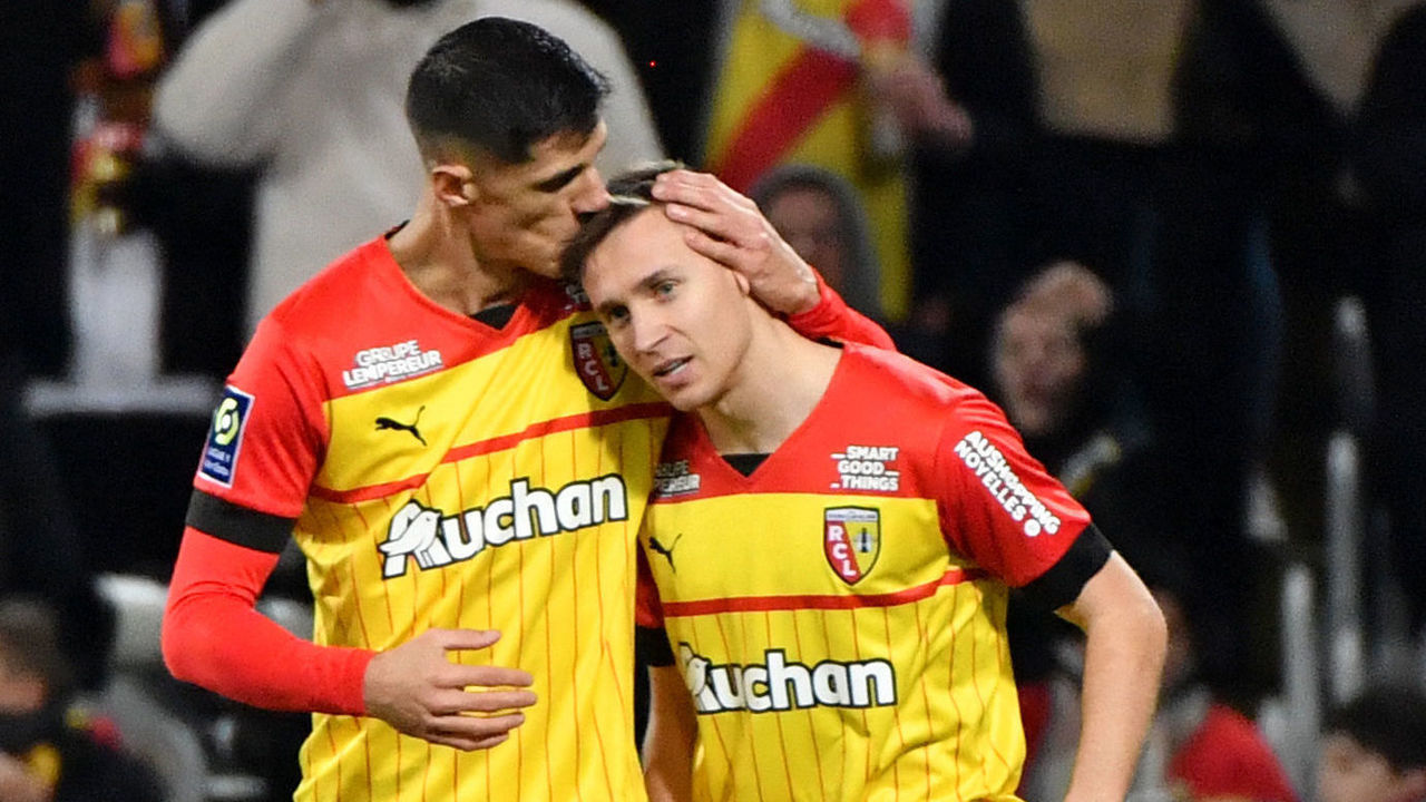 Lens' Polish defender Przemyslaw Frankowski (R) is congratulated by a team mate after scoring a goal during the French L1 football match between RC Lens and AJ Auxerre at the Bollaert-Delelis stadium in Lens on January 14, 2023.