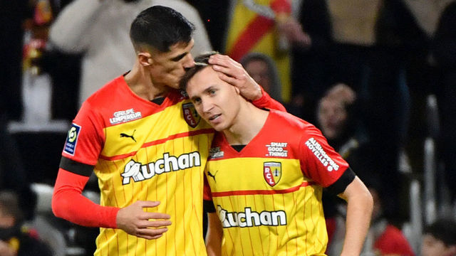 Lens' Polish defender Przemyslaw Frankowski (R) is congratulated by a team mate after scoring a goal during the French L1 football match between RC Lens and AJ Auxerre at the Bollaert-Delelis stadium in Lens on January 14, 2023.