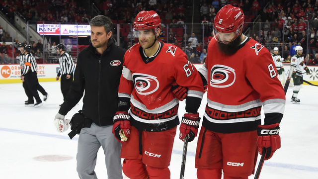 RALEIGH, NC - JANUARY 19: Carolina Hurricanes head athletic trainer Doug Bennett and Carolina Hurricanes Defenceman Brent Burns (8) help Carolina Hurricanes Left Wing Max Pacioretty (67) off the ice after an injury during the game between the Minnesota Wild and the Carolina Hurricanes on January 19, 2023 at PNC Arena in Raleigh, North Carolina.
