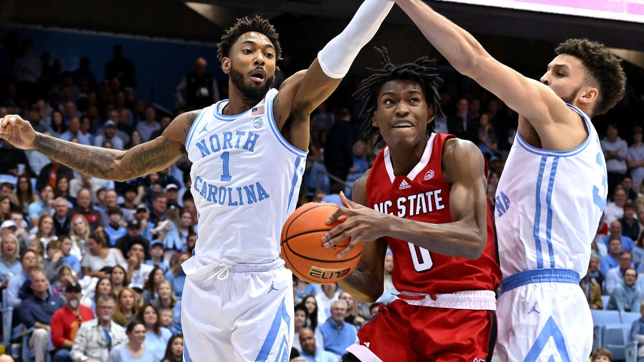 CHAPEL HILL, NORTH CAROLINA - JANUARY 21: Terquavion Smith #0 of the North Carolina State Wolfpack drives between Leaky Black #1 and Pete Nance #32 of the North Carolina Tar Heels during the first half of their game at the Dean E. Smith Center on January 21, 2023 in Chapel Hill, North Carolina.