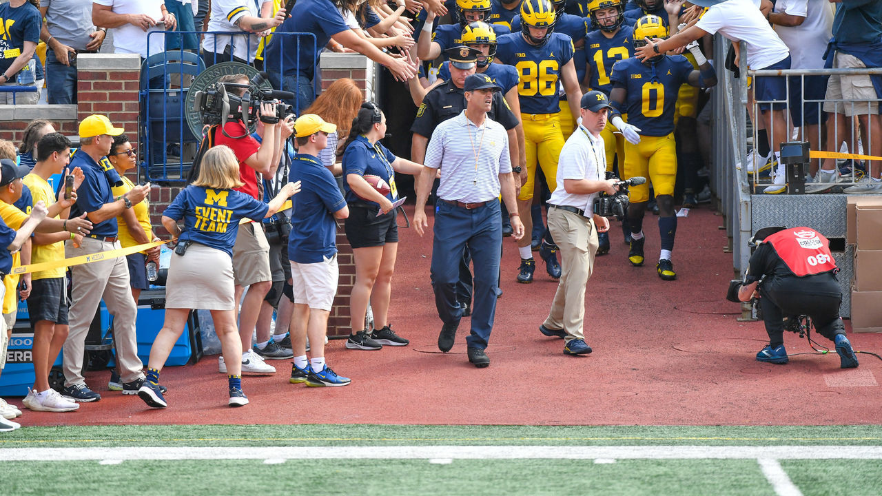 ANN ARBOR, MICHIGAN - SEPTEMBER 17: Head Football Coach Jim Harbaugh of the Michigan Wolverines walks his team out of the tunnel before oa college football game against the Connecticut Huskies at Michigan Stadium on September 17, 2022 in Ann Arbor, Michigan.