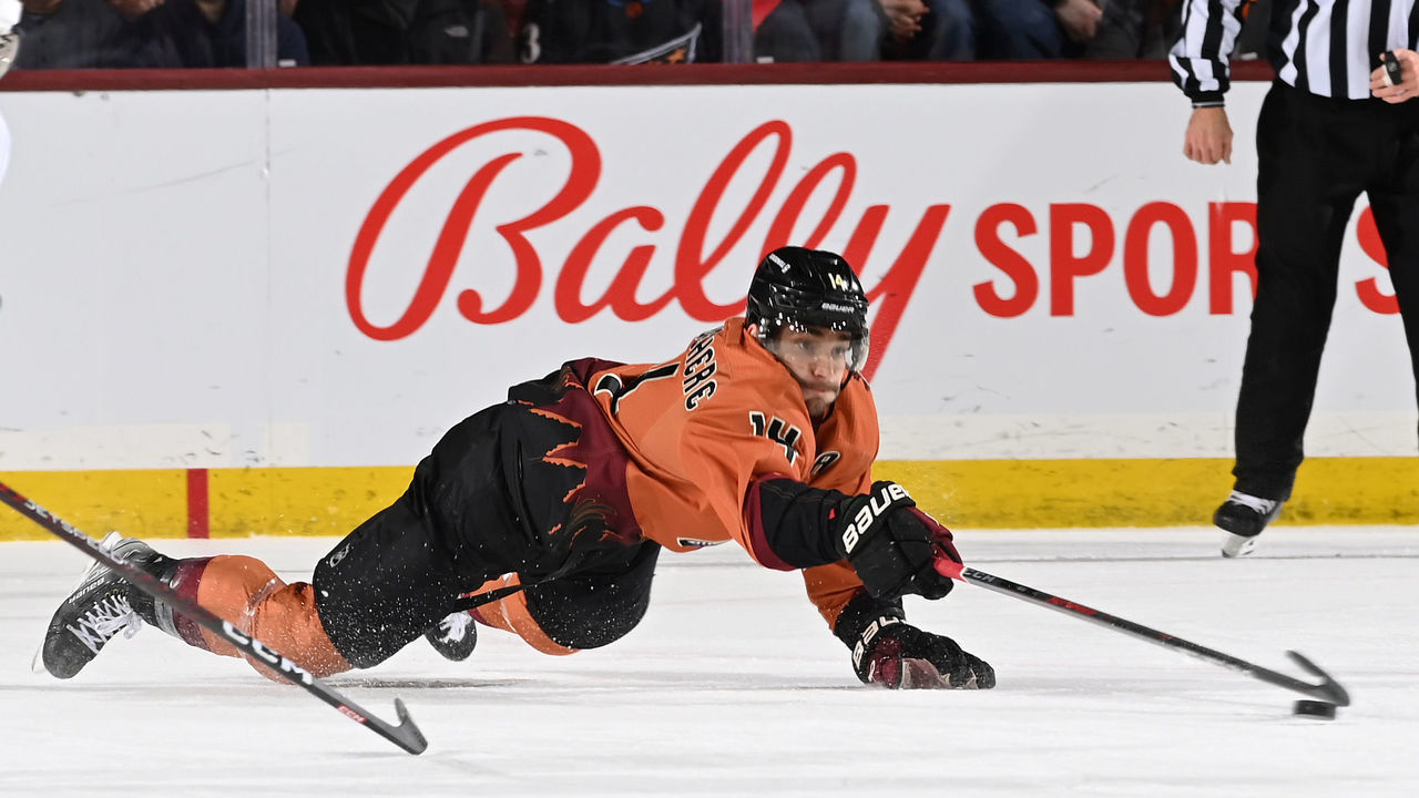 TEMPE, ARIZONA - JANUARY 19: Shayne Gostisbehere #14 of the Arizona Coyotes dives for a loose puck against the Washington Capitals at Mullett Arena on January 19, 2023 in Tempe, Arizona.