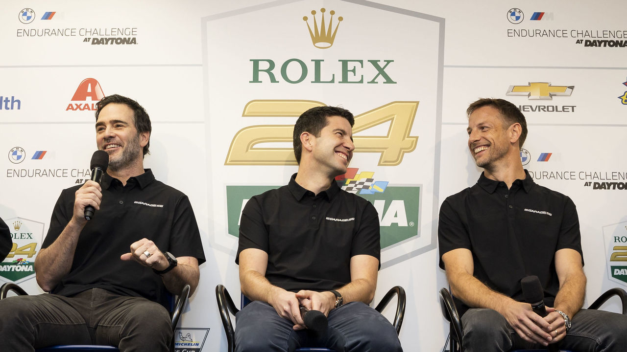 DAYTONA BEACH, FLORIDA - JANUARY 28: (L-R) President of IMSA John Doonan, Drivers Jimmie Johnson, Mike Rockenfeller, and Jenson Button speak to the media during a press conference announcing the NASCAR Garage 56 driver lineup for entry in 2023 Le mans before the Rolex 24 at Daytona International Speedway on January 28, 2023 in Daytona Beach, Florida.