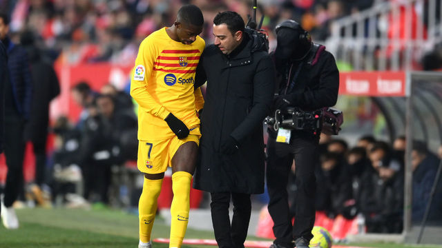 GIRONA, SPAIN - JANUARY 28: Ousmane Dembele of FC Barcelona leaves the field after picking up an injury as they speak with Xavi, Head Coach of FC Barcelona, during the LaLiga Santander match between Girona FC and FC Barcelona at Montilivi Stadium on January 28, 2023 in Girona, Spain.