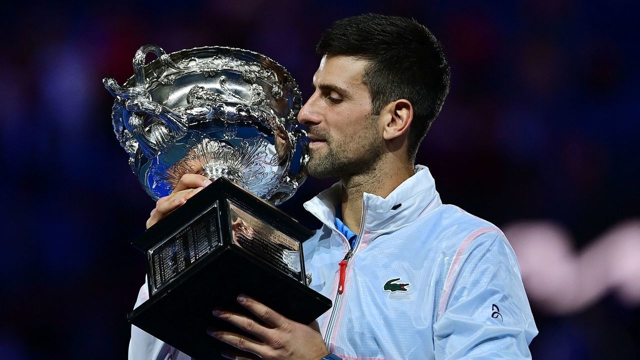 Serbia's Novak Djokovic celebrates with the Norman Brookes Challenge Cup trophy following his victory against Greece's Stefanos Tsitsipas in the men's singles final match on day fourteen of the Australian Open tennis tournament in Melbourne on January 29, 2023. - -- IMAGE RESTRICTED TO EDITORIAL USE - STRICTLY NO COMMERCIAL USE --