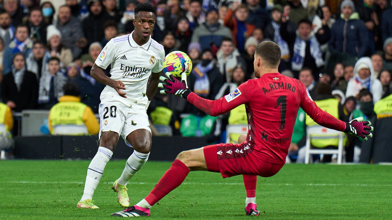 MADRID, SPAIN - JANUARY 29: Alex Remiro of Real Sociedad makes a save from Vinicius Junior of Real Madrid during the LaLiga Santander match between Real Madrid CF and Real Sociedad at Estadio Santiago Bernabeu on January 29, 2023 in Madrid, Spain.