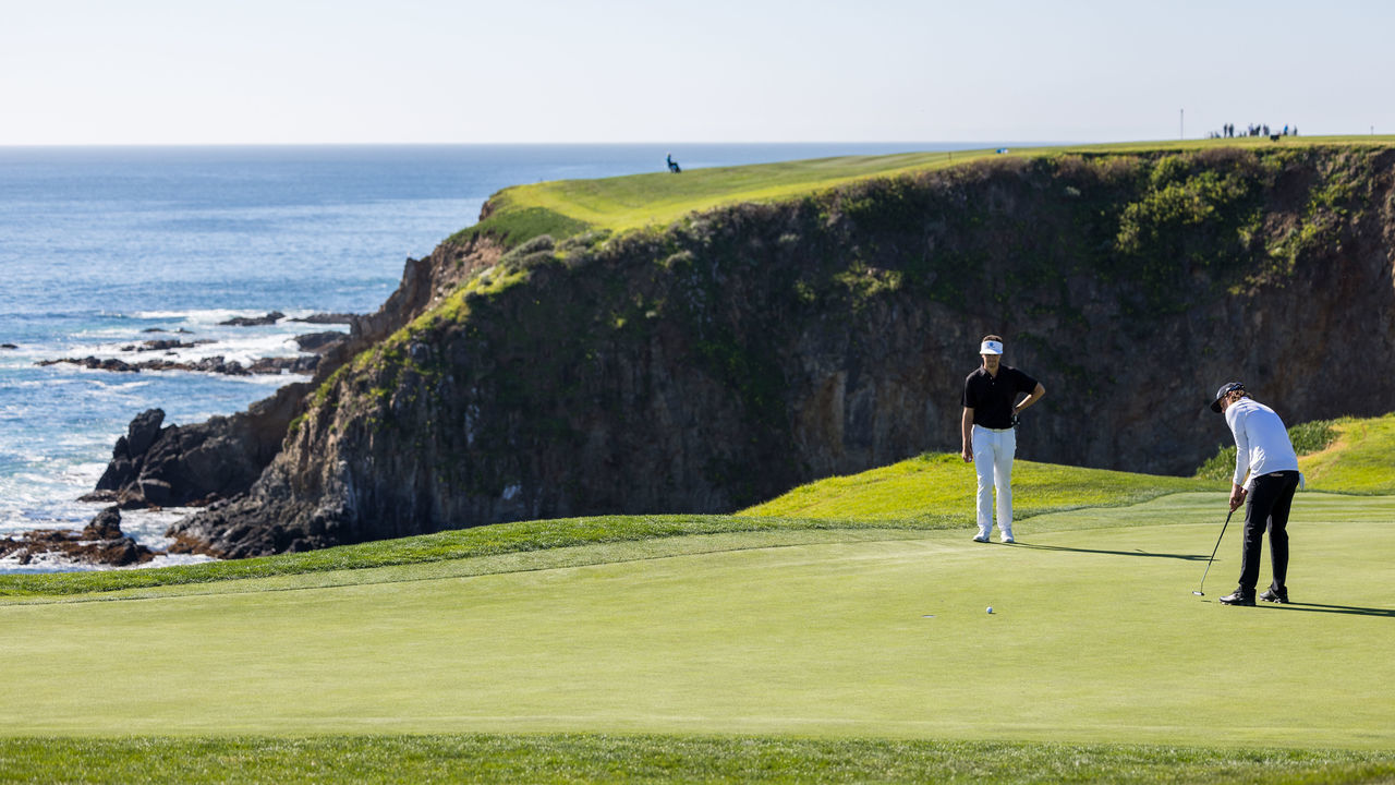 PEBBLE BEACH, CA - FEBRUARY 06: American PGA professional golfer Andrew Putnam putts while American PGA professional golfer Beau Hossler looks on during the PGA AT&T Pebble Beach Pro-Am on February 6, 2022 at Pebble Beach Golf Links in Pebble Beach, CA.