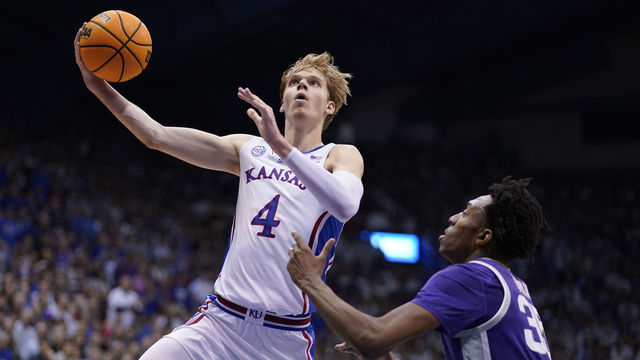 LAWRENCE, KANSAS - JANUARY 31: Gradey Dick #4 of the Kansas Jayhawks lays the ball up against Nae'Qwan Tomlin #35 of the Kansas State Wildcats in the first half at Allen Fieldhouse on January 31, 2023 in Lawrence, Kansas.