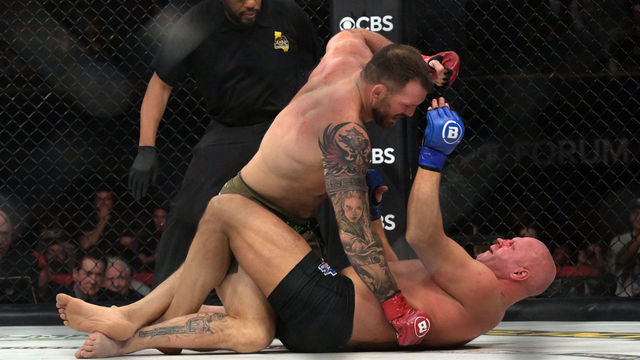 Inglewood, CA - February 04: Ryan Bader, red gloves, hits Fedor Emelianenko,blue gloves, during their heavyweight championship fight during Bellator 290: Bader vs. Fedor 2 at the Kia Forum in Inglewood, CA, Saturday, Feb 4, 2023. The fight was the last for Emelianenkos career and he was defeated by Bader by first round TKO.