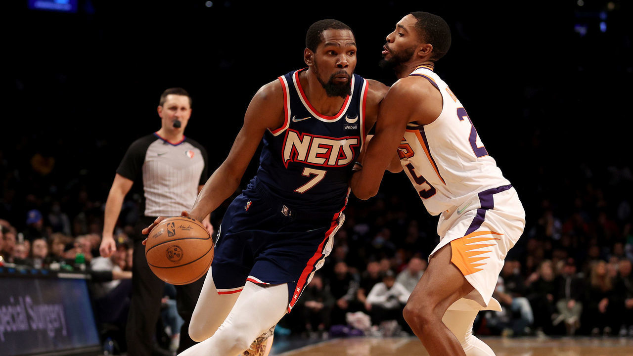 NEW YORK, NEW YORK - NOVEMBER 27: Kevin Durant #7 of the Brooklyn Nets heads for the net as Mikal Bridges #25 of the Phoenix Suns defends at Barclays Center on November 27, 2021 in New York City. The Phoenix Suns defeated the Brooklyn Nets 113-107.