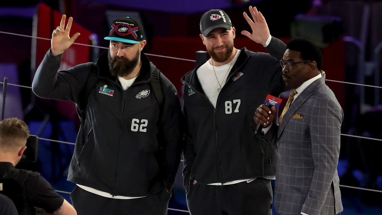 PHOENIX, ARIZONA - FEBRUARY 06: (L-R) Brothers Jason Kelce #62 of the Philadelphia Eagles and Travis Kelce #87 of the Kansas City Chiefs wave onstage during Super Bowl LVII Opening Night presented by Fast Twitch at Footprint Center on February 06, 2023 in Phoenix, Arizona.