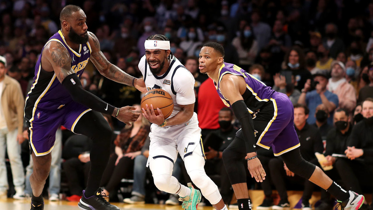 LOS ANGELES, CALIFORNIA - FEBRUARY 16: Mike Conley #11 of the Utah Jazz drives to the basket against LeBron James #6 and Russell Westbrook #0 of the Los Angeles Lakers during the fourth quarter at Crypto.com Arena on February 16, 2022 in Los Angeles, California.
