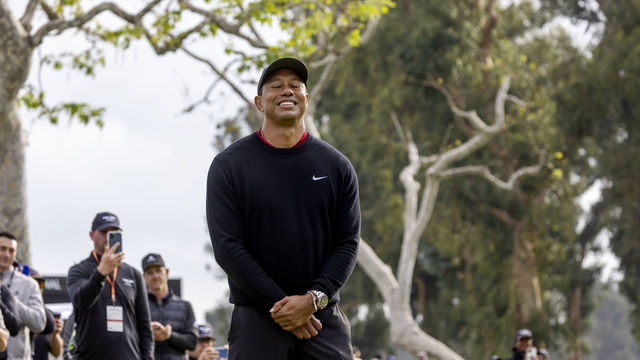 PACIFIC PALISADES, CA - FEBRUARY 20, 2022: Tournament host Tiger Woods takes in the moment as winner Joaquin Niemann holds the trophy after the final round of the Genesis Invitational at Riviera Country Club on February 20, 2022 in Pacific Palisades, California.One year ago, Woods was involved in a car accident the day after the tournament.(Gina Ferazzi / Los Angeles Times via Getty Images)