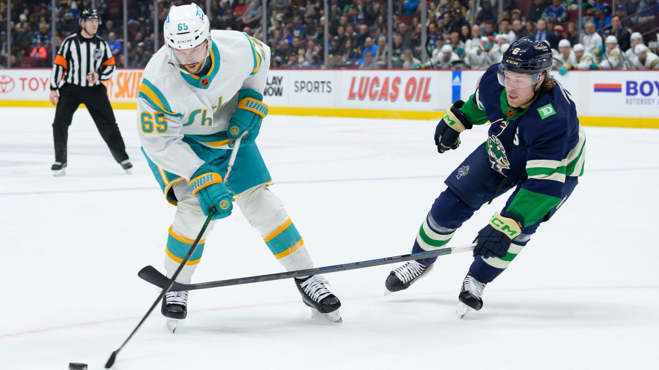 VANCOUVER, CANADA - DECEMBER 27: Brock Boeser #6 of the Vancouver Canucks defends against Erik Karlsson #65 of the San Jose Sharks during the first period of their NHL game at Rogers Arena on December 27, 2022 in Vancouver, British Columbia, Canada.