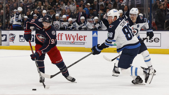 COLUMBUS, OHIO - FEBRUARY 16: Kent Johnson #91 of the Columbus Blue Jackets skates with the puck as Nate Schmidt #88 of the Winnipeg Jets defends during the first period of a game at Nationwide Arena on February 16, 2023 in Columbus, Ohio.