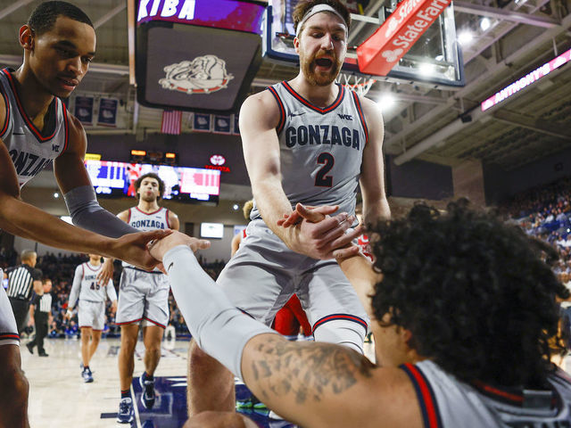 SPOKANE, WA - JANUARY 19: Gonzaga Bulldogs forward Drew Timme (2) and Gonzaga Bulldogs guard Nolan Hickman (11) help Gonzaga Bulldogs guard Julian Strawther (0) up during the game between the Loyola Marymount Lions and the Gonzaga Bulldogs on January 19, 2023, at McCarthey Athletic Center in Spokane, WA.