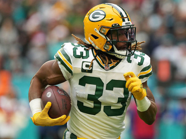 MIAMI GARDENS, FLORIDA - DECEMBER 25: Aaron Jones #33 of the Green Bay Packers rushes the ball during the first quarter of the game against the Miami Dolphins at Hard Rock Stadium on December 25, 2022 in Miami Gardens, Florida.