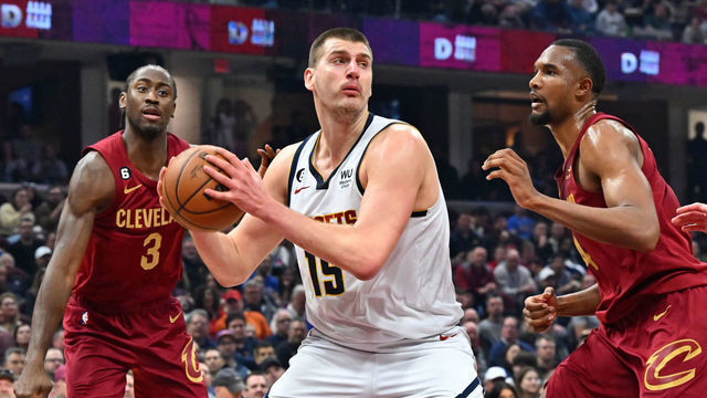 CLEVELAND, OHIO - FEBRUARY 23: Caris LeVert #3 and Evan Mobley #4 of the Cleveland Cavaliers guard Nikola Jokic #15 of the Denver Nuggets during the first quarter at Rocket Mortgage Fieldhouse on February 23, 2023 in Cleveland, Ohio.
