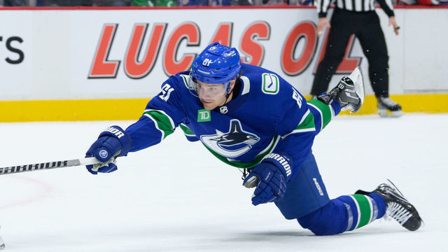 VANCOUVER, CANADA - FEBRUARY 15: Artemi Panarin #10 of the New York Rangers skates with the puck ahead of Riley Stillman #61 of the Vancouver Canucks during the second period of their NHL game at Rogers Arena on February 15, 2023 in Vancouver, British Columbia, Canada.