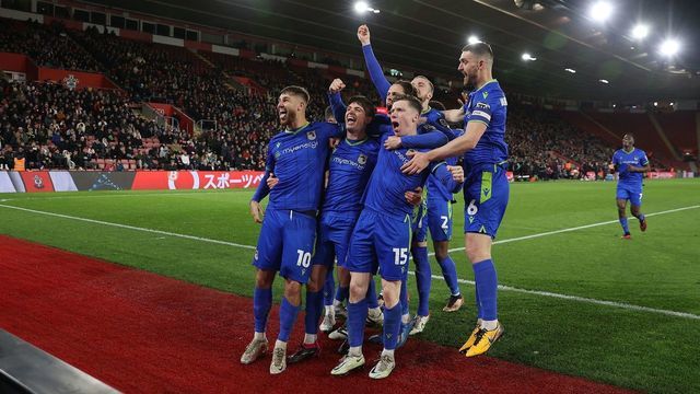 Grimsby's Irish midfielder Gavan Holohan is mobbed by teammates after scoring the team's second goal during the English FA Cup fifth round football match between Southampton and Grimsby Town at St Mary's Stadium in Southampton, southern England on March 1, 2023.