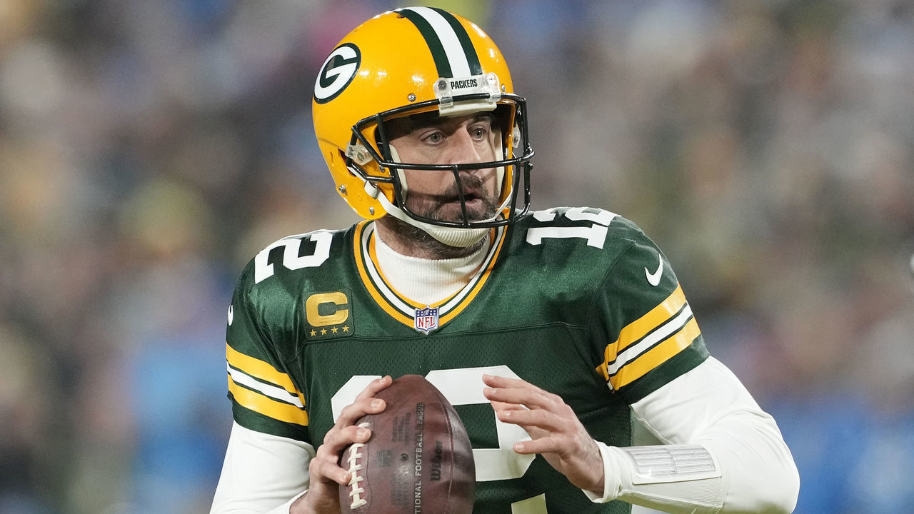 GREEN BAY, WISCONSIN - JANUARY 08: Aaron Rodgers #12 of the Green Bay Packers scrambles with the ball against the Detroit Lions in the first half at Lambeau Field on January 08, 2023 in Green Bay, Wisconsin.