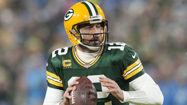 GREEN BAY, WISCONSIN - JANUARY 08: Aaron Rodgers #12 of the Green Bay Packers scrambles with the ball against the Detroit Lions in the first half at Lambeau Field on January 08, 2023 in Green Bay, Wisconsin.