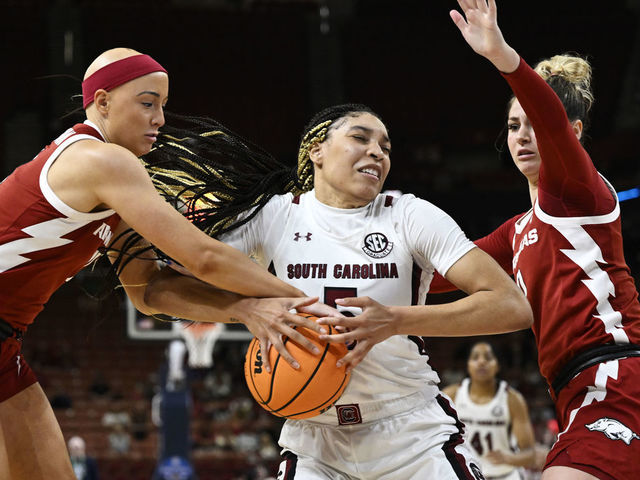 GREENVILLE, SOUTH CAROLINA - MARCH 03: Victaria Saxton #5 of the South Carolina Gamecocks wrestles for the ball with Rylee Langerman #11 and Saylor Poffenbarger #0 of the Arkansas Razorbacks in the third quarter during the quarterfinals of the SEC Women's Basketball Tournament at Bon Secours Wellness Arena on March 03, 2023 in Greenville, South Carolina.
