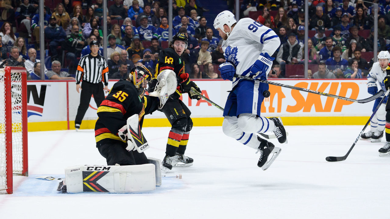 VANCOUVER, CANADA - MARCH 4: Thatcher Demko #35 of the Vancouver Canucks defends as Ryan O'Reilly #90 of the Toronto Maple Leafs is hit by the puck during the second period of their NHL game at Rogers Arena on March 4, 2023 in Vancouver, British Columbia, Canada.