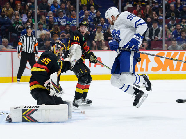 VANCOUVER, CANADA - MARCH 4: Thatcher Demko #35 of the Vancouver Canucks defends as Ryan O'Reilly #90 of the Toronto Maple Leafs is hit by the puck during the second period of their NHL game at Rogers Arena on March 4, 2023 in Vancouver, British Columbia, Canada.
