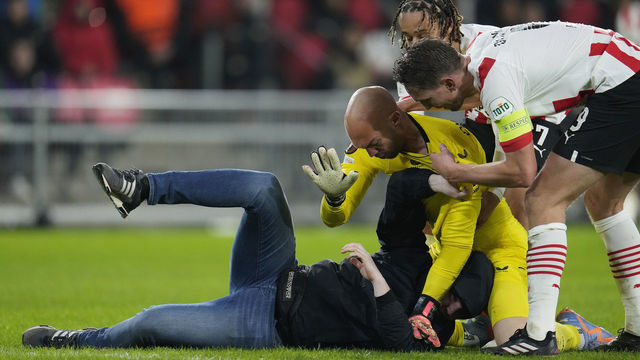 EINDHOVEN, NETHERLANDS - FEBRUARY 23: Pitch entrant in combat with Marko Dmitrovic of Sevilla FC, Xavi Simons of PSV, Luuk de Jong of PSV during the UEFA Europa League match between PSV v Sevilla at the Philips Stadium on February 23, 2023 in Eindhoven Netherlands