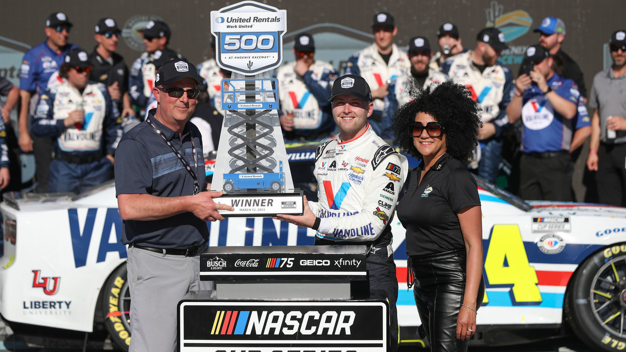AVONDALE, ARIZONA - MARCH 12: William Byron, driver of the #24 Valvoline Chevrolet, is presented the United Rentals Work United 500 trophy in victory lane after winning the NASCAR Cup Series United Rentals Work United 500 at Phoenix Raceway on March 12, 2023 in Avondale, Arizona.