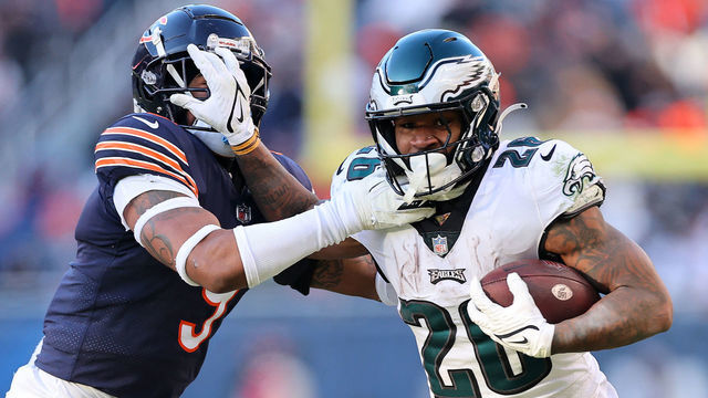 CHICAGO, ILLINOIS - DECEMBER 18: Miles Sanders #26 of the Philadelphia Eagles stiff arms Jaquan Brisker #9 of the Chicago Bears during the second half at Soldier Field on December 18, 2022 in Chicago, Illinois.