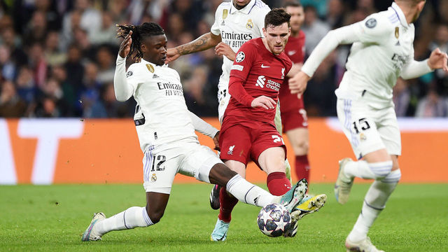 MADRID, SPAIN - MARCH 15: Andrew Robertson of Liverpool passes the ball whilst under pressure from Eduardo Camavinga of Real Madrid during the UEFA Champions League round of 16 leg two match between Real Madrid and Liverpool FC at Estadio Santiago Bernabeu on March 15, 2023 in Madrid, Spain.