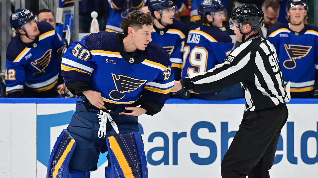 ST. LOUIS, MO - MARCH 15: St. Louis Blues goaltender Jordan Binnington (50) is restrained by linesman David Brisebois after he left the crease. His action drew a suspension and a five-minute major penalty during a NHL game between the Minnesota Wild and the St. Louis Blues on March 15, 2023, at Enterprise Center in St. Louis, MO