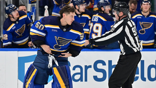 ST. LOUIS, MO - MARCH 15: St. Louis Blues goaltender Jordan Binnington (50) is restrained by linesman David Brisebois after he left the crease. His action drew a suspension and a five-minute major penalty during a NHL game between the Minnesota Wild and the St. Louis Blues on March 15, 2023, at Enterprise Center in St. Louis, MO