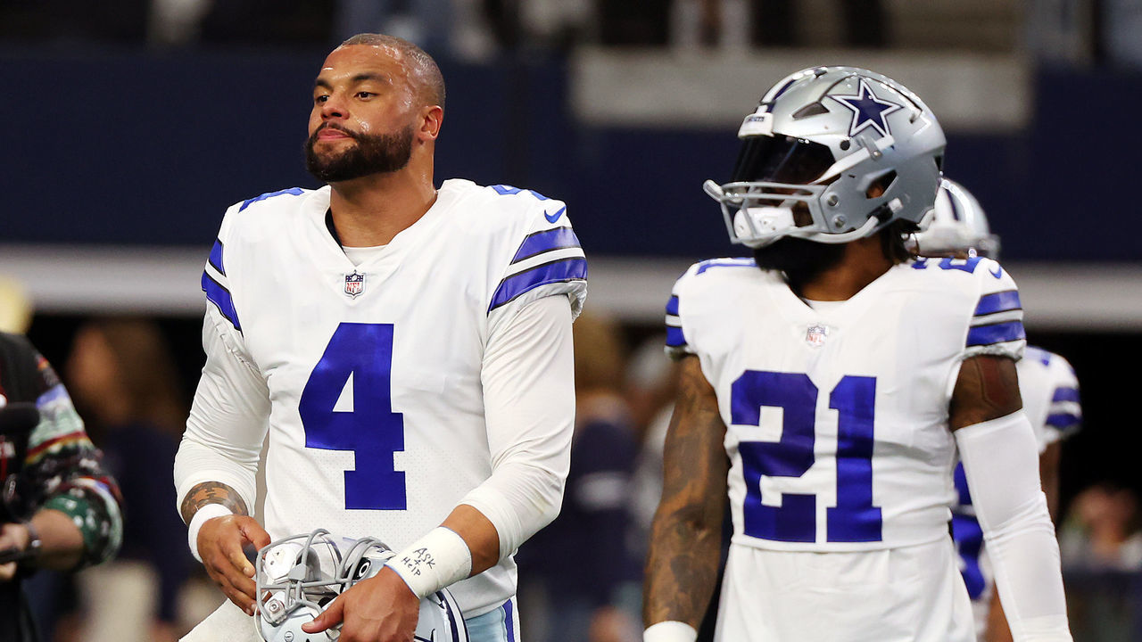 ARLINGTON, TEXAS - DECEMBER 24: Dak Prescott #4 and Ezekiel Elliott #21 of the Dallas Cowboys walk on the field during warmups at AT&T Stadium on December 24, 2022 in Arlington, Texas.