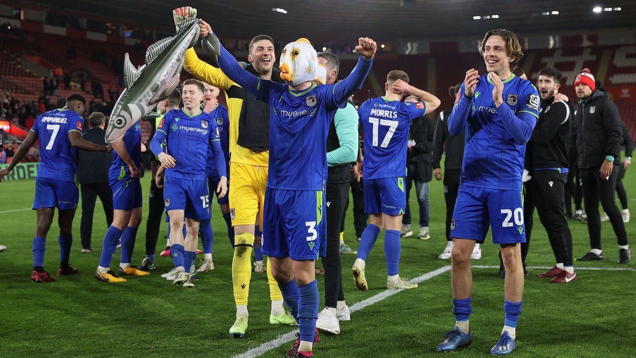 Grimsby's English defender Anthony Glennon (C) wears a fish on his head whilst holding an inflatable fish as he celebrates with teammates after the English FA Cup fifth round football match between Southampton and Grimsby Town at St Mary's Stadium in Southampton, southern England on March 1, 2023. - Grimsby won the match 2-1.