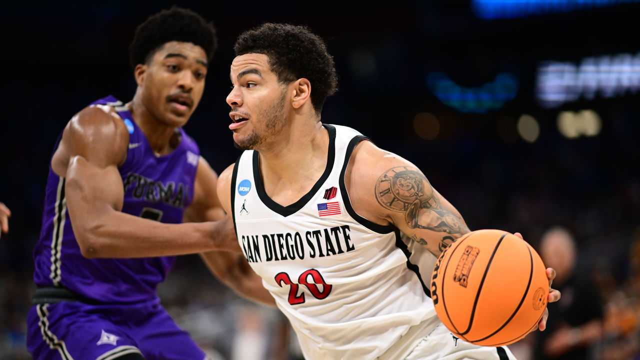 ORLANDO, FL - MARCH 18: Matt Bradley #20 of the San Diego State Aztecs drives to the basket against Marcus Foster #5 of the Furman Paladins during the second round of the 2023 NCAA Men's Basketball Tournament held at Amway Center on March 18, 2023 in Orlando, Florida.