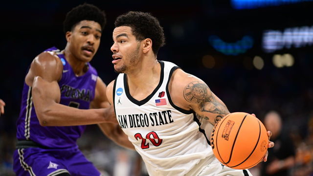 ORLANDO, FL - MARCH 18: Matt Bradley #20 of the San Diego State Aztecs drives to the basket against Marcus Foster #5 of the Furman Paladins during the second round of the 2023 NCAA Men's Basketball Tournament held at Amway Center on March 18, 2023 in Orlando, Florida.