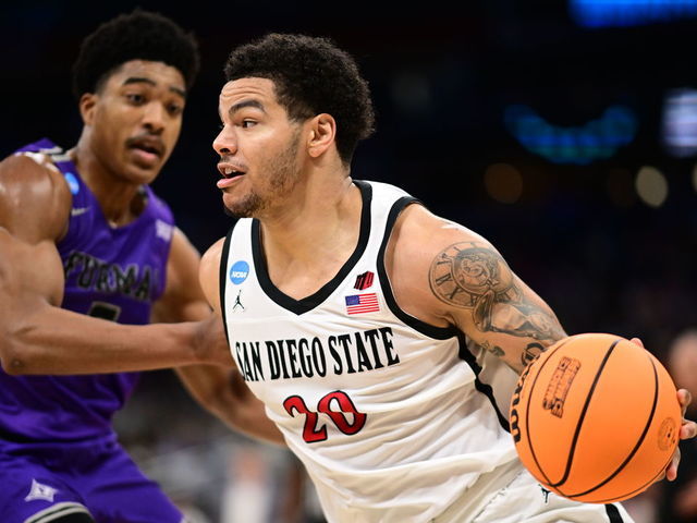 ORLANDO, FL - MARCH 18: Matt Bradley #20 of the San Diego State Aztecs drives to the basket against Marcus Foster #5 of the Furman Paladins during the second round of the 2023 NCAA Men's Basketball Tournament held at Amway Center on March 18, 2023 in Orlando, Florida.