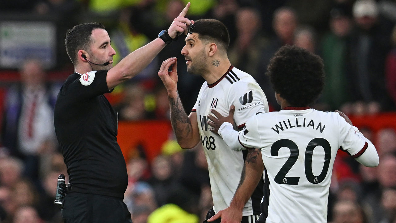 Fulham's Serbian striker Aleksandar Mitrovic (C) is restrained by Fulham's Brazilian midfielder Willian (R) after being shown a red card by English referee Chris Kavanagh (L) during the English FA Cup quarter-final football match between Manchester United and Fulham at Old Trafford in Manchester, north-west England, on March 19, 2023.